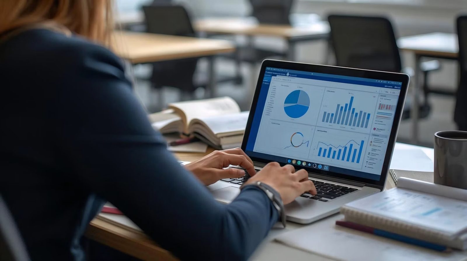 Analyst reviewing financial dashboards and charts on a laptop